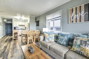 a living room with a couch and a table at Cozy Ocean Isle Beach Condo, Steps to the Beach! in Ocean Isle Beach