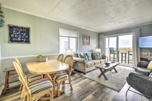 a living room with a table and a couch at Cozy Ocean Isle Beach Condo, Steps to the Beach! in Ocean Isle Beach