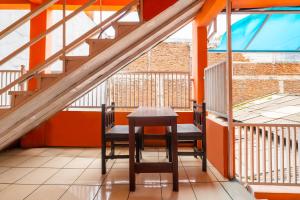 einen Tisch und Stühle auf einem Balkon mit orangefarbenen Wänden in der Unterkunft OYO 2562 Pondok Tajlibu Syifa Syariah in Bandung