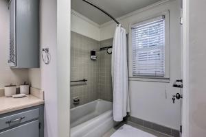 Un baño blanco con bañera y ducha. en Walk to Broad St Central Thomasville Condo, en Thomasville 18 fotos más