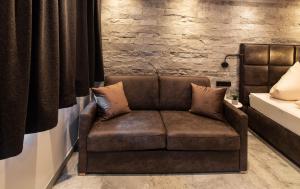 a brown couch in a room with a brick wall at The VIEW - KAPRUN in Kaprun