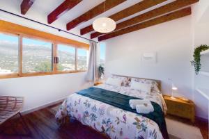 une chambre avec un lit et une grande fenêtre dans l'établissement Apartamento de diseño en Casco antiguo Altea, à Altea