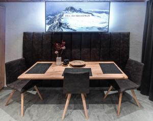 a wooden table with two chairs and a picture on the wall at The VIEW - KAPRUN in Kaprun