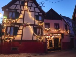Una vecchia casa con le luci di Natale sopra. di Gites Aux Fines Bulles d'Alsace SPA privatif en supplément a Bergheim