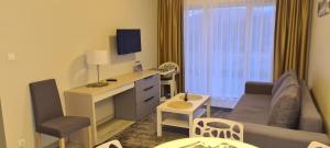 une chambre d'hôtel avec un bureau et un salon avec un canapé dans l'établissement Apartament Czarna Góra Is1, à Sienna
