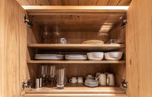 a wooden cabinet with plates and dishes in it at The VIEW - KAPRUN in Kaprun