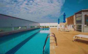 a large swimming pool in a large building at FLAT exclusivo no Hotel RAMADA Macaé, Smartv, Wifi 512Mbps, piscina e Garagem in Macaé