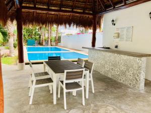 zona de comedor con mesa y sillas y piscina en Departamento "Sparanise", en Playa del Carmen