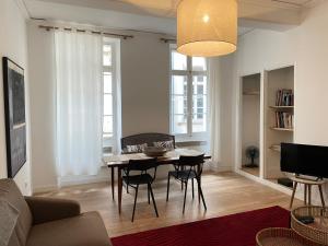 a living room with a table and chairs and a couch at Maison Lligat, appartements dans le centre historique in Perpignan