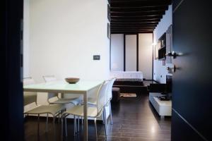 une salle à manger avec une table et des chaises blanches dans l'établissement Casa Falco, à Turin