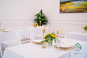 a white table with white chairs and flowers on it at Selecthotel Hạ Long in Ha Long +66 photos