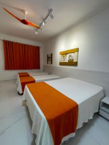 ein Schlafzimmer mit zwei Betten und einem roten Vorhang in der Unterkunft FLAT AMARÍLIS - RIVIERA DE SÃO LOURENçO in Riviera de São Lourenço