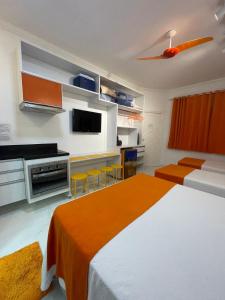 um quarto de hotel com duas camas e uma cozinha em FLAT AMARÍLIS - RIVIERA DE SÃO LOURENÇo em Riviera de São Lourenço