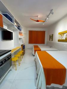 ein Hotelzimmer mit 2 Betten und gelben Stühlen in der Unterkunft FLAT AMARÍLIS - RIVIERA DE SÃO LOURENçO in Riviera de São Lourenço