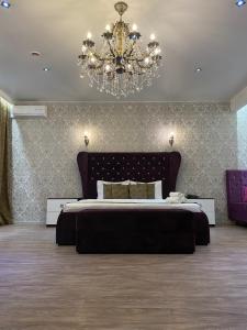 a large bedroom with a large bed and a chandelier at Boutique hotel Statler in Biysk