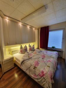 ブラウンラーゲにあるFewo Haudeのベッドルーム1室(ピンクの花が咲くベッド1台付)