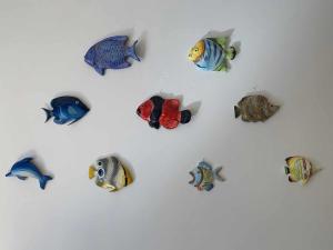 a group of fish figurines on a white wall at Pitosforo in Zoagli