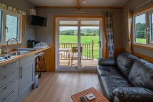 uma sala de estar com um sofá e uma cozinha com um alpendre em The Elm Shepod - Smardale Mill em Smardale