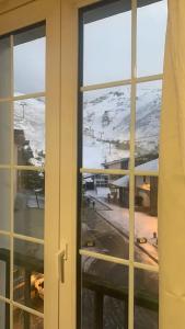 a view of a snowy mountain through a window at Apartamento a pie de pista en edificio Enebro con parking in Sierra Nevada