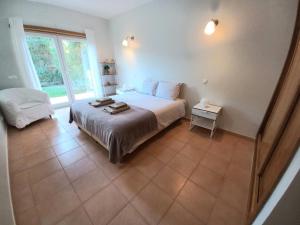 a bedroom with a bed and a large window at Casa da Praia in Sagres