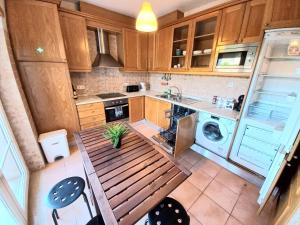 a small kitchen with a wooden table and a sink at Casa da Praia in Sagres