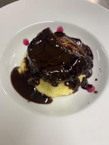 un morceau de gâteau avec une sauce au chocolat sur une assiette blanche dans l'établissement Albergo Castiglione Langhe, à Castiglione Tinella