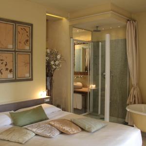 Spazio[Bianco] في إيفريا: غرفة نوم بسرير وحمام مع حوض استحمام