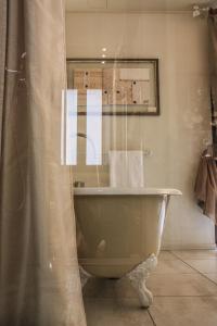 y baño con bañera y cortina de ducha. en Spazio[Bianco], en Ivrea