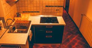 a small kitchen with a stove and a sink at Incantevole Maisonette nelle Alpi Cuneesi in San Giacomo
