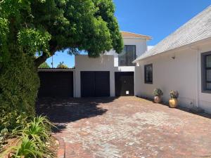 uma casa branca com uma garagem e uma árvore em 7 on Jansenstreet em Cidade do Cabo