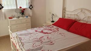 a bedroom with a bed with a red blanket and a dresser at Casa Algorfa Alicante Spain in Algorfa