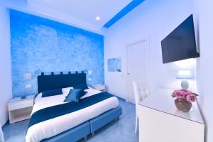 a blue bedroom with a bed and a blue wall at Sea MaVi Forio in Forio d'Ischia