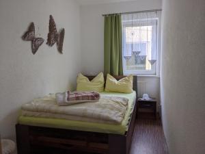 Dormitorio pequeño con cama con mariposas en la pared en Ferienwohnung in der Altstadt von Coswig Anhalt en Coswig