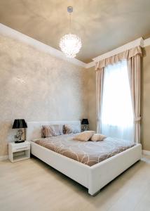 a bedroom with a large bed and a chandelier at Parliment Luxury Apartment in Budapest