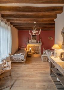 ein Wohnzimmer mit roten Wänden und einem Kamin in der Unterkunft Entre Loire et Sologne Maison d'hôtes in Saint-Gervais-la-Forêt