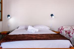 łóżko z 2 poduszkami w pokoju w obiekcie Chalé aconchegante com Wi-Fi no Vale do Capão - BA w mieście Vale do Capao