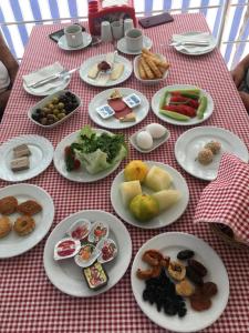 een tafel met borden met voedsel op een rood gecontroleerd tafelkleed bij Mucize Termal Spa in Pamukkale