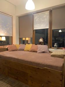 a large wooden bed in a room with windows at Zeleni svet 2 in Crni Vrh