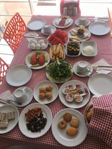 uma mesa com pratos de comida numa toalha de mesa vermelha controlada em Mucize Termal Spa em Pamukkale