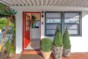 una casa con una puerta roja y algunas plantas en Oasis Hotel en Fort Lauderdale