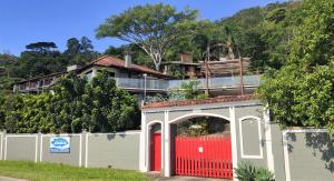 a red brick building with a red fence at Pousada Ecomar in Florianópolis