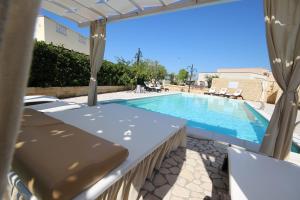 uma piscina com mesa e cadeiras ao lado de uma piscina em Villa B&B Antiche Macine del Salento - nel cuore del Salento em Salve