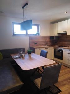 a kitchen with a wooden table and a dining room at rima apartments in Hippach