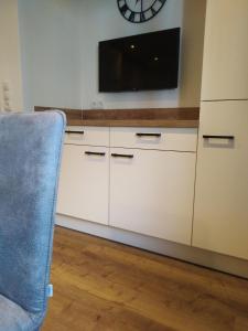 a living room with a tv and a chair at rima apartments in Hippach