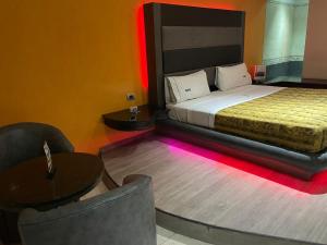 a bedroom with a bed and a table and a chair at Motel Fronorte in Mexicali