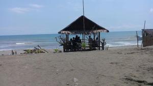 a group of people sitting in a gazebo on the beach at Damara Beachfront Resort in Baler