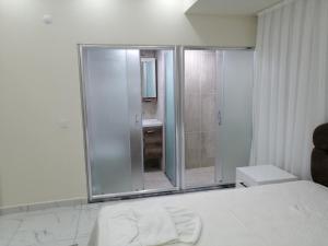 a white bathroom with a shower and a bed at Deniz Apart in Demre