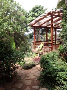 einen hölzernen Pavillon mit einer Bank im Garten in der Unterkunft Lushoto Pazuri in Makungulu
