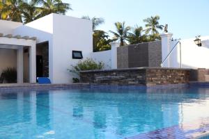 a swimming pool with a blue and white swimming pool at Mar Sol Bungalows & Hotel in Mazatlán