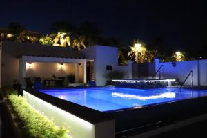 a house with a swimming pool at night at Mar Sol Bungalows & Hotel in Mazatlán